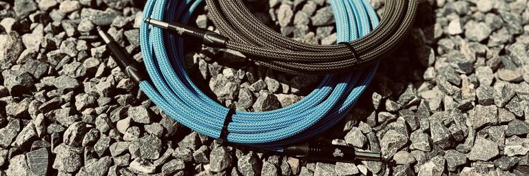 Niebieski i czarny kabel instrumentalny w oplocie na żwirze